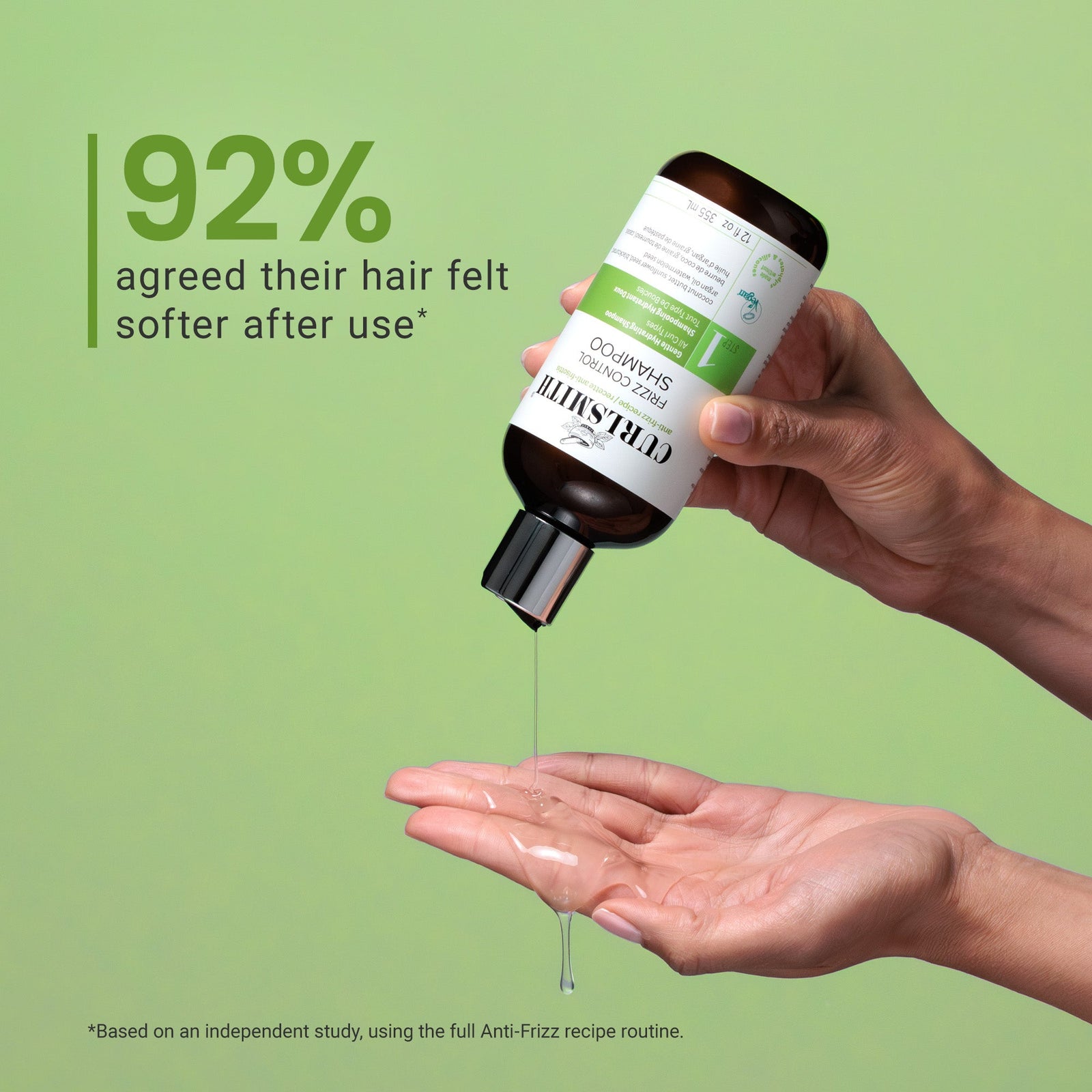 Hand holding a bottle of frizz control shampoo with text on a green background