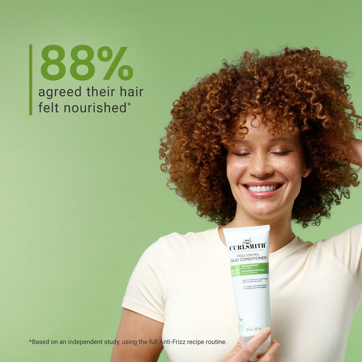 Woman holding a Curlsmith frizz control conditioner with a green background and text about hair nourishment.