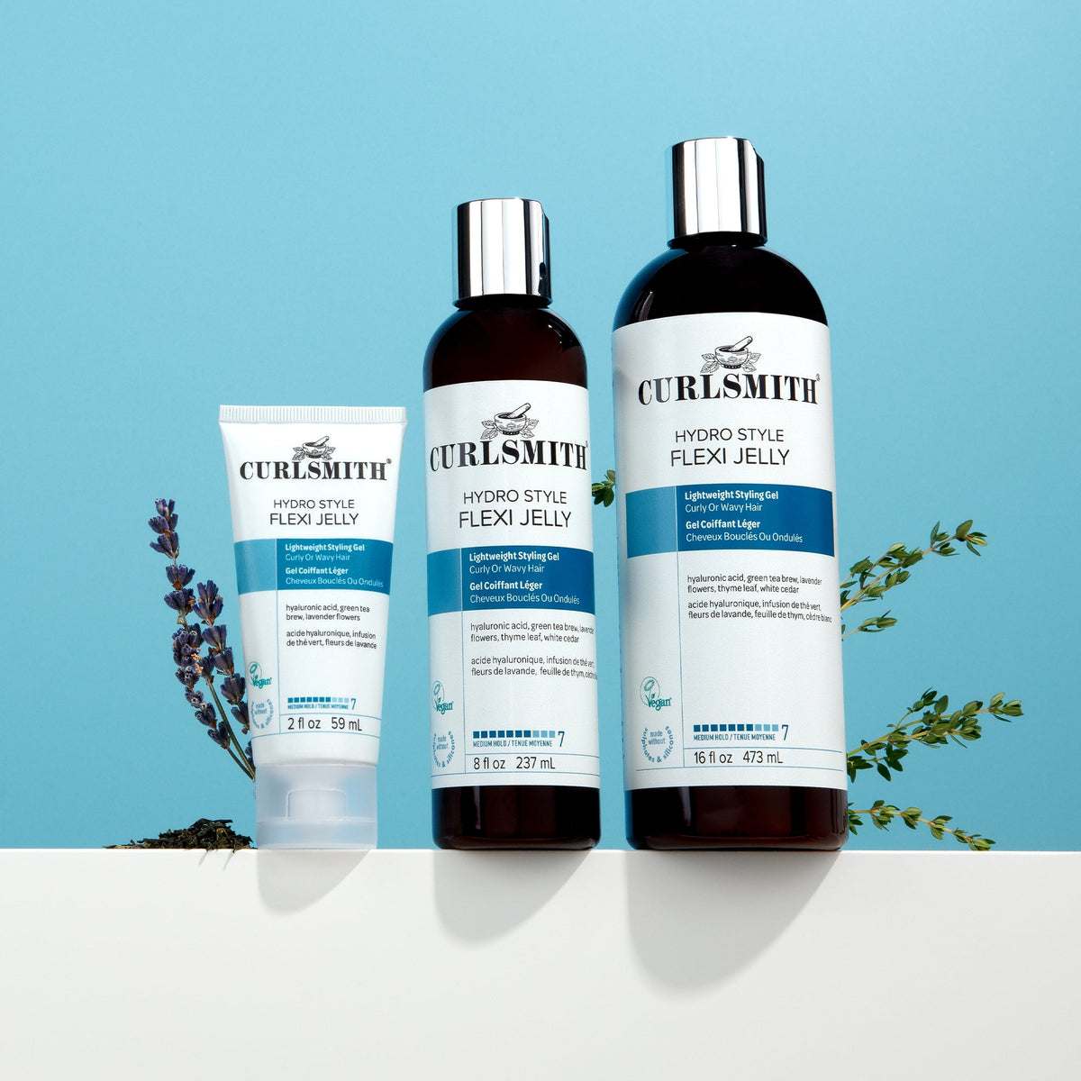 Curlsmith Hydro Style Flexi Jelly hair care products in different sizes on a blue background