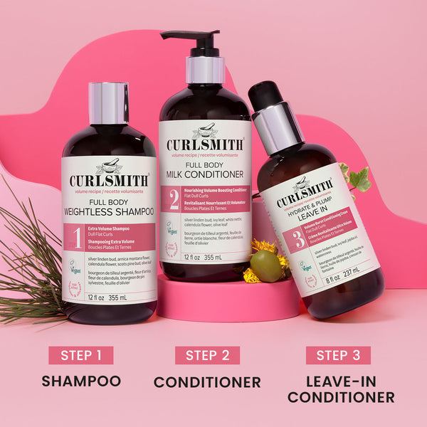 Three bottles of Curlsmith volume hair care products on a pink background