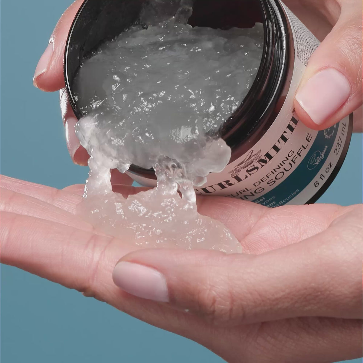 Hand dipping jar of Curl Defining souffle jelly into other hand