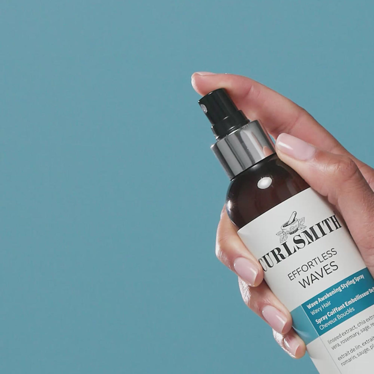Hand spraying Effortless Waves bottle