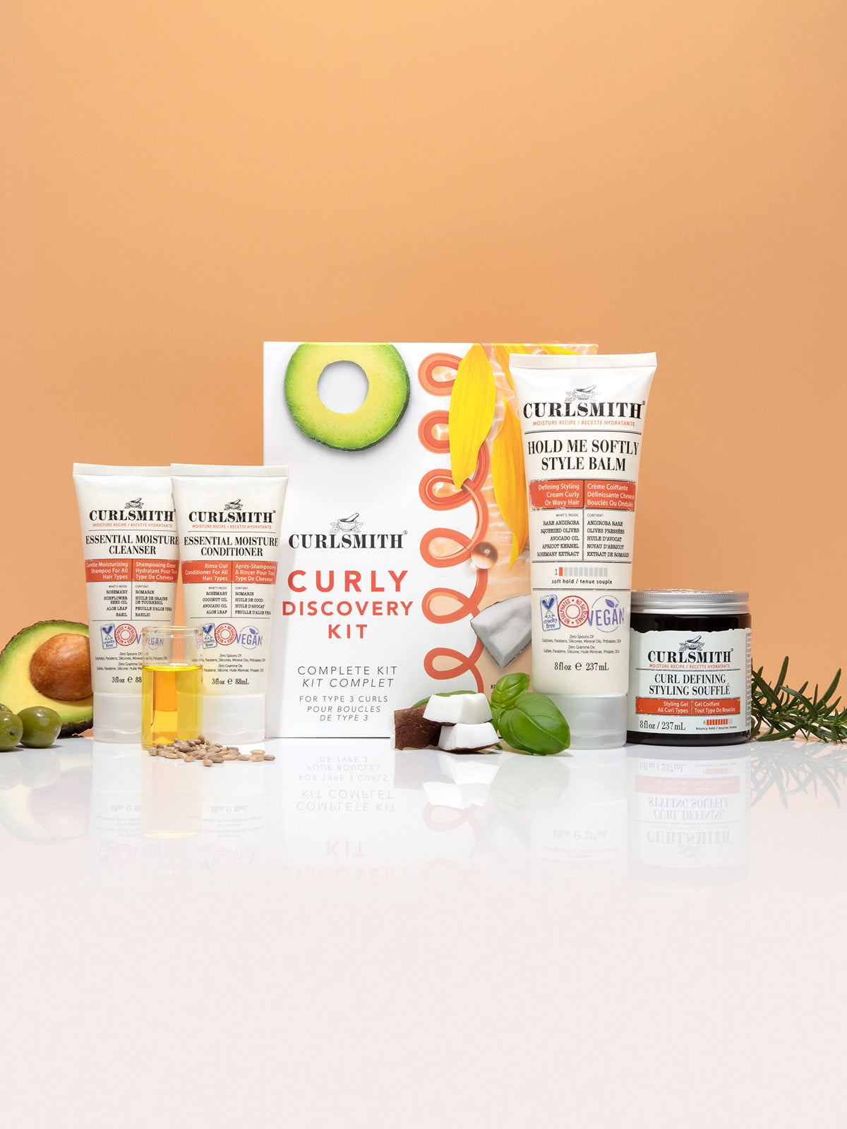 A product image featuring the Curly Discovery Kit by Curlsmith, which includes various hair care products and an instruction booklet, all themed with an orange color scheme.