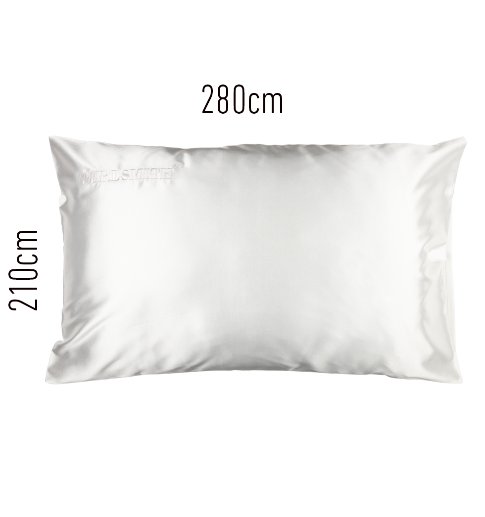A white satin pillowcase on a pillow, with a subtle sheen.