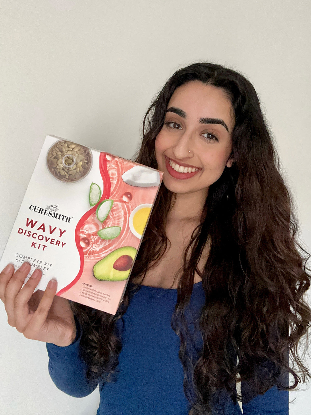 Wavy woman holding wavy hair care product set