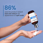 Hand holding a Bond curl rehab salve bottle of hair care product with a dropper, against a blue background.