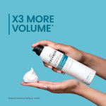 Hand holding a bottle of Invincible Volume Mousse with foam on a blue background, promoting 'X3 More Volume'.
