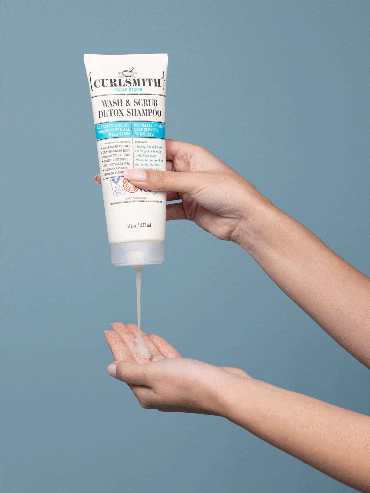 Hand squeezing detox shampoo into the other hand