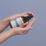 Hand pumping Curlshield Cream into other hand.