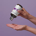 Hand squeezing bottle of Core strength shampoo into other hand