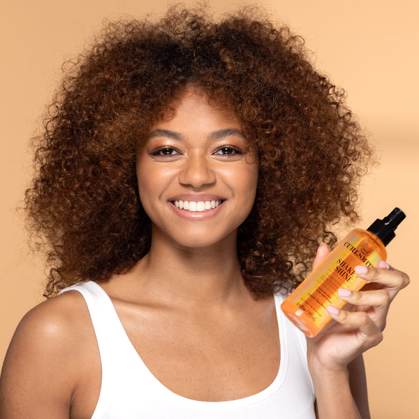 Woman holding a bottle of Shake & Shine product against a beige background