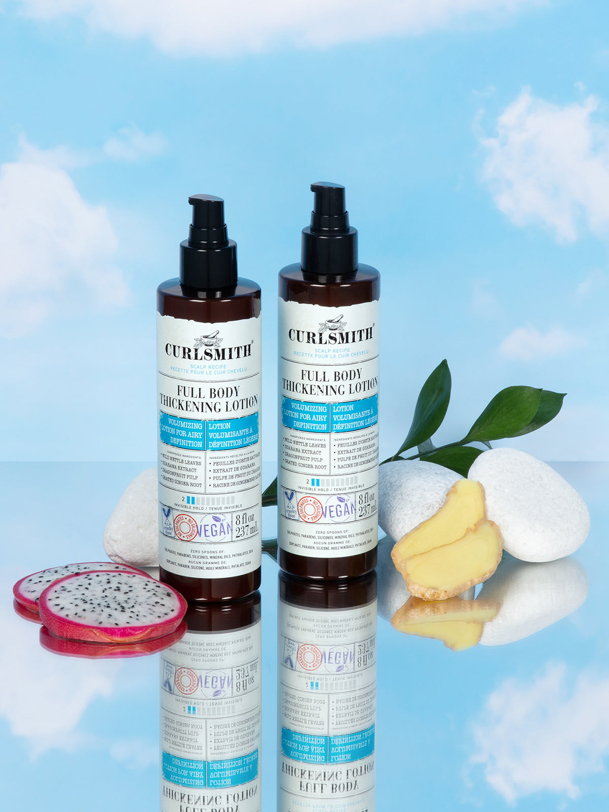 Two bottles of Curlsmith Full Body Thickening Lotion on a reflective surface with a blue sky background.