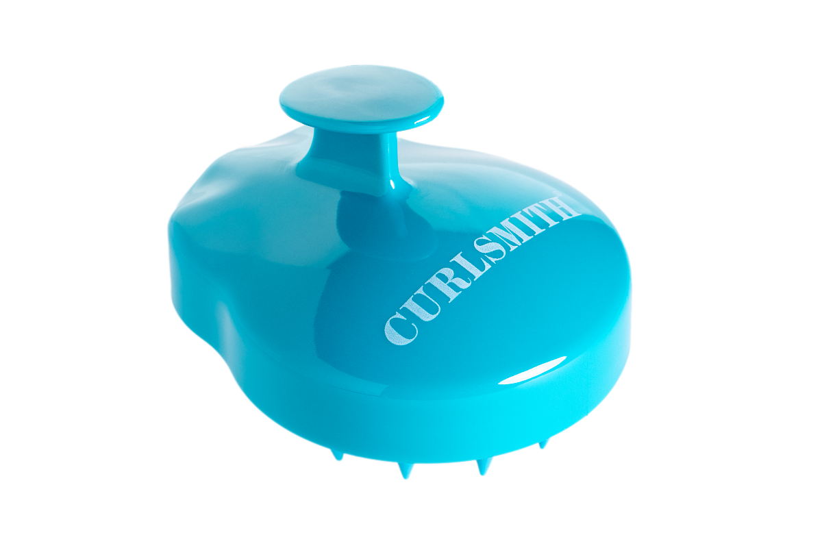 A blue scalp massager with the brand name Curlsmith inscribed on it.