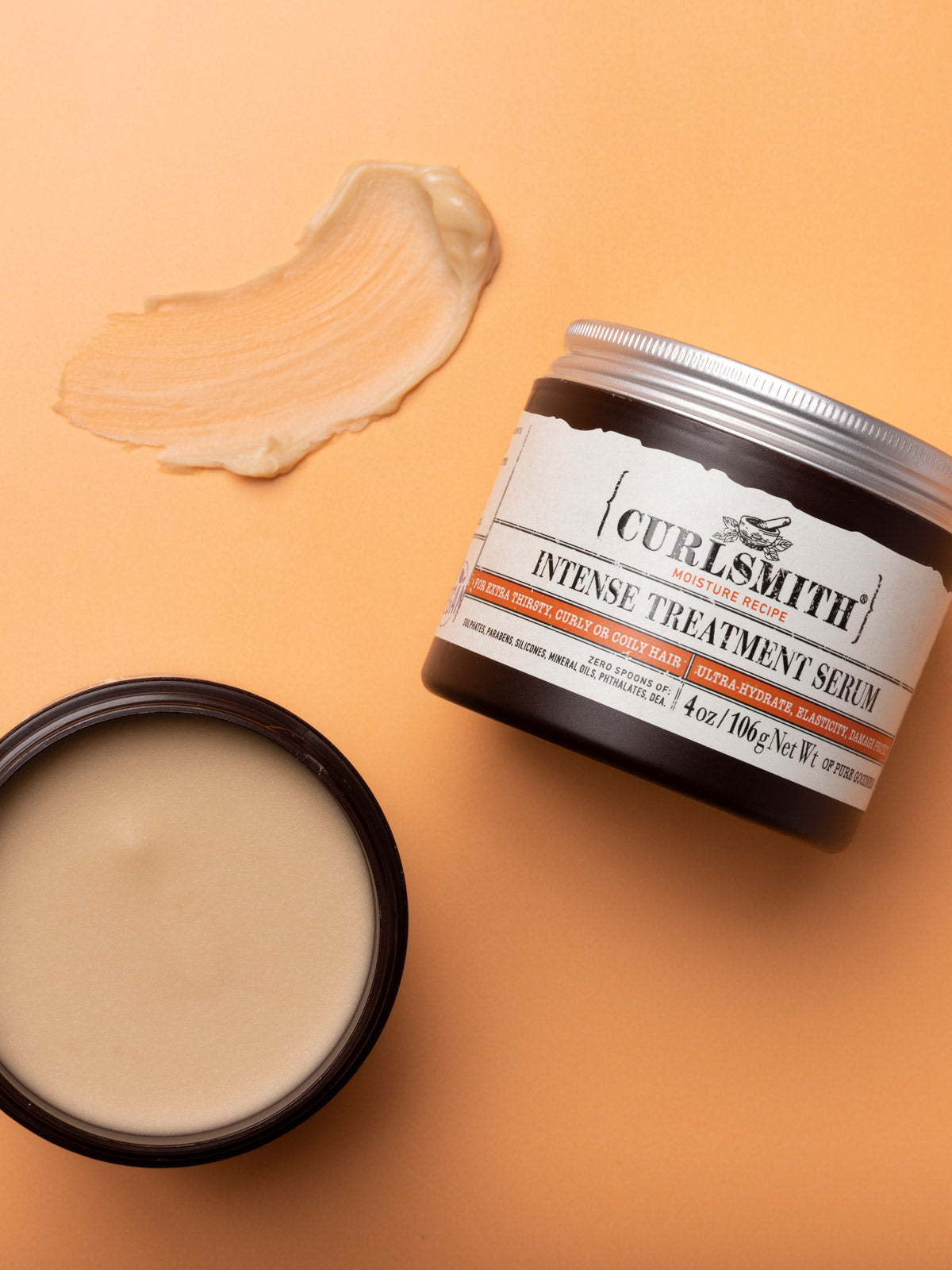 Curlsmith intense treatment serum jar with features on an orange background