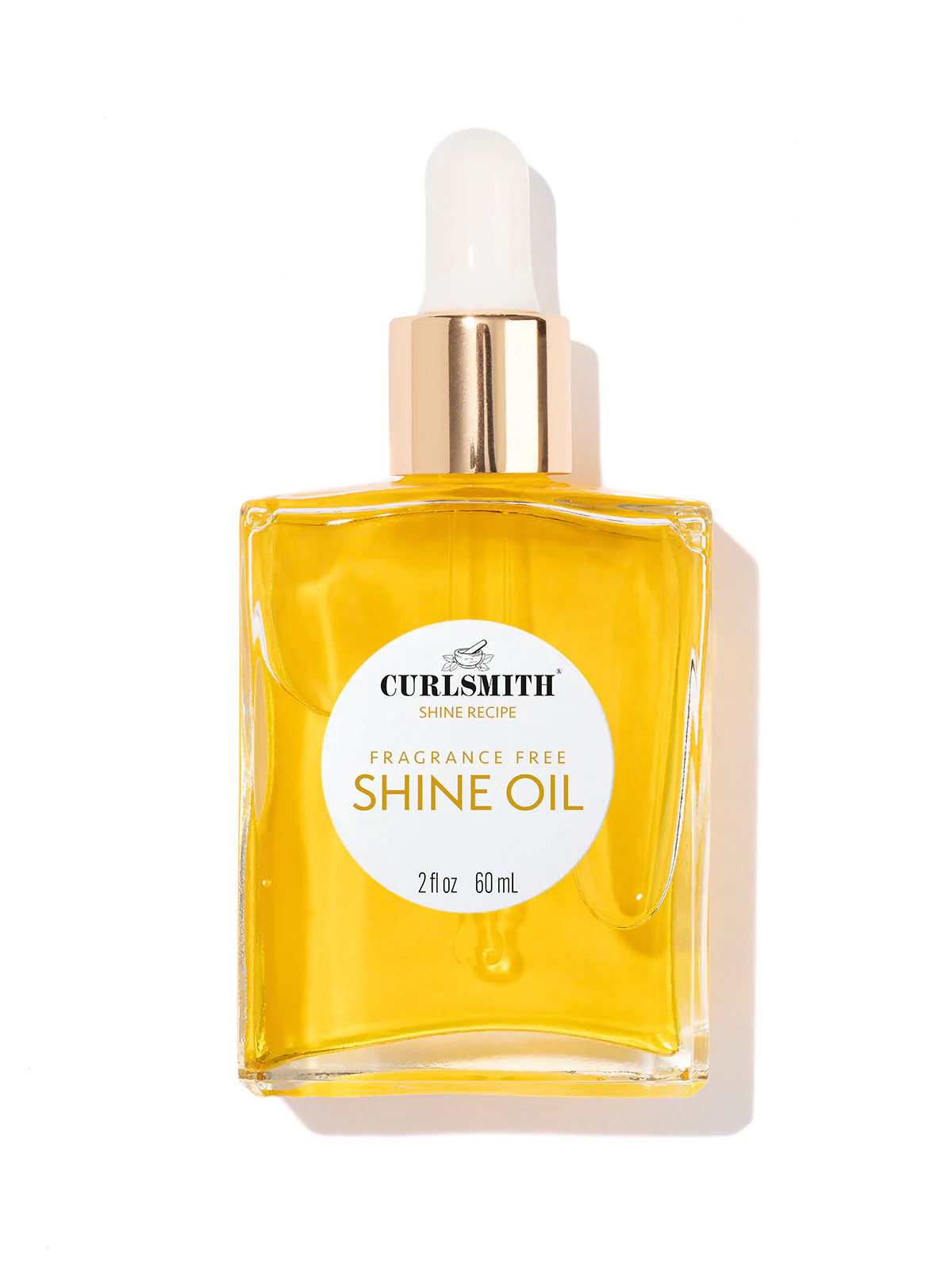 A clear glass bottle with a dropper filled with yellow liquid, labeled 'SHINE OIL' from Curlsmith.