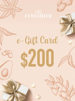 An e-Gift Card from Curlsmith featuring a $200 denomination, with decorative elements such as leaves and gift boxes in blue tones.