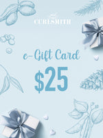 An e-Gift Card from Curlsmith featuring a $25 denomination, with decorative elements such as leaves and gift boxes in blue tones.