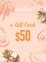 An e-Gift Card from Curlsmith featuring a $50 denomination, with decorative elements such as leaves and gift boxes in blue tones.